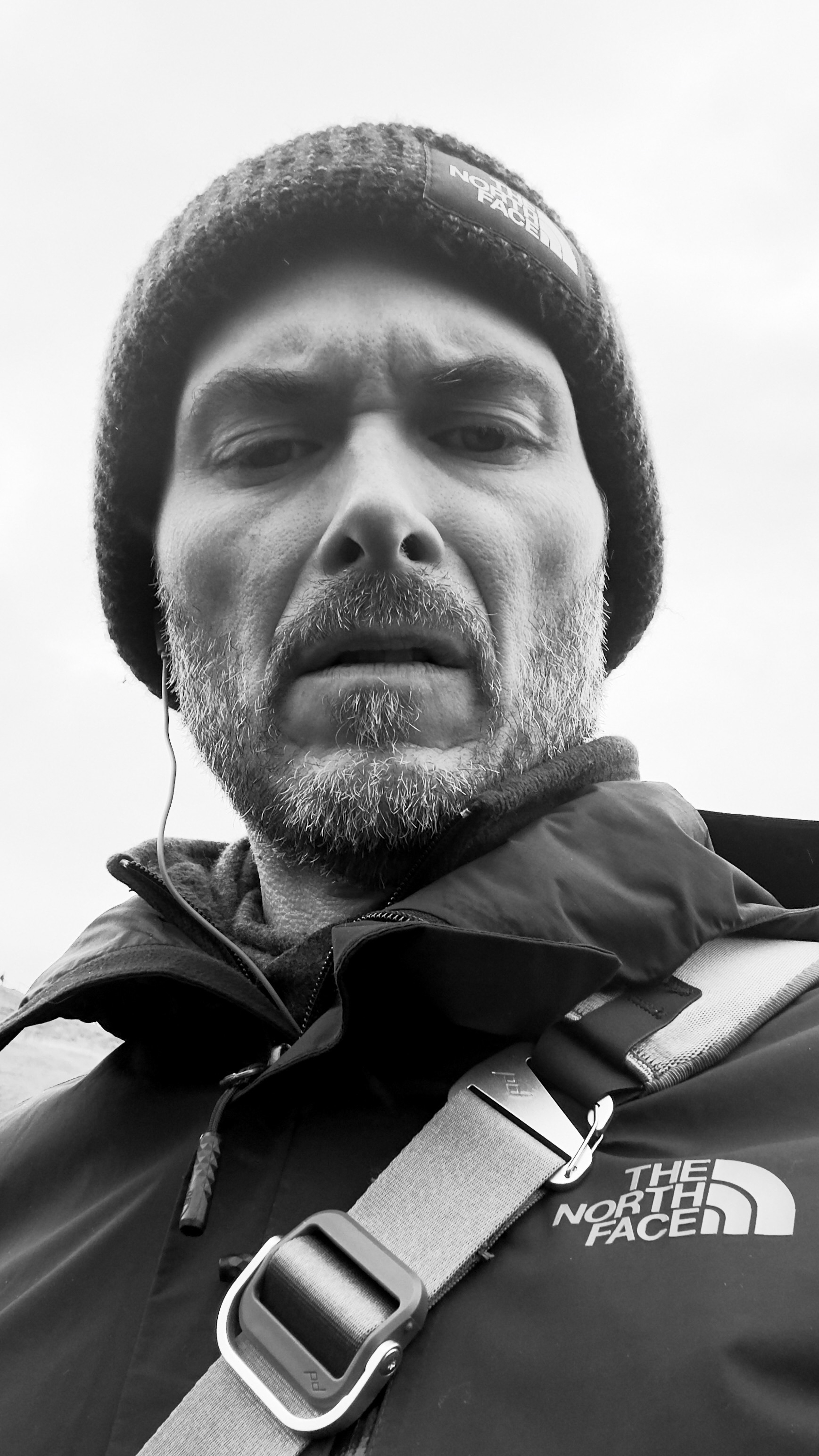 Black and white selfie, looking very moody and annoyed. Northface hat and jacket to help keep the cold of Iceland at bay.